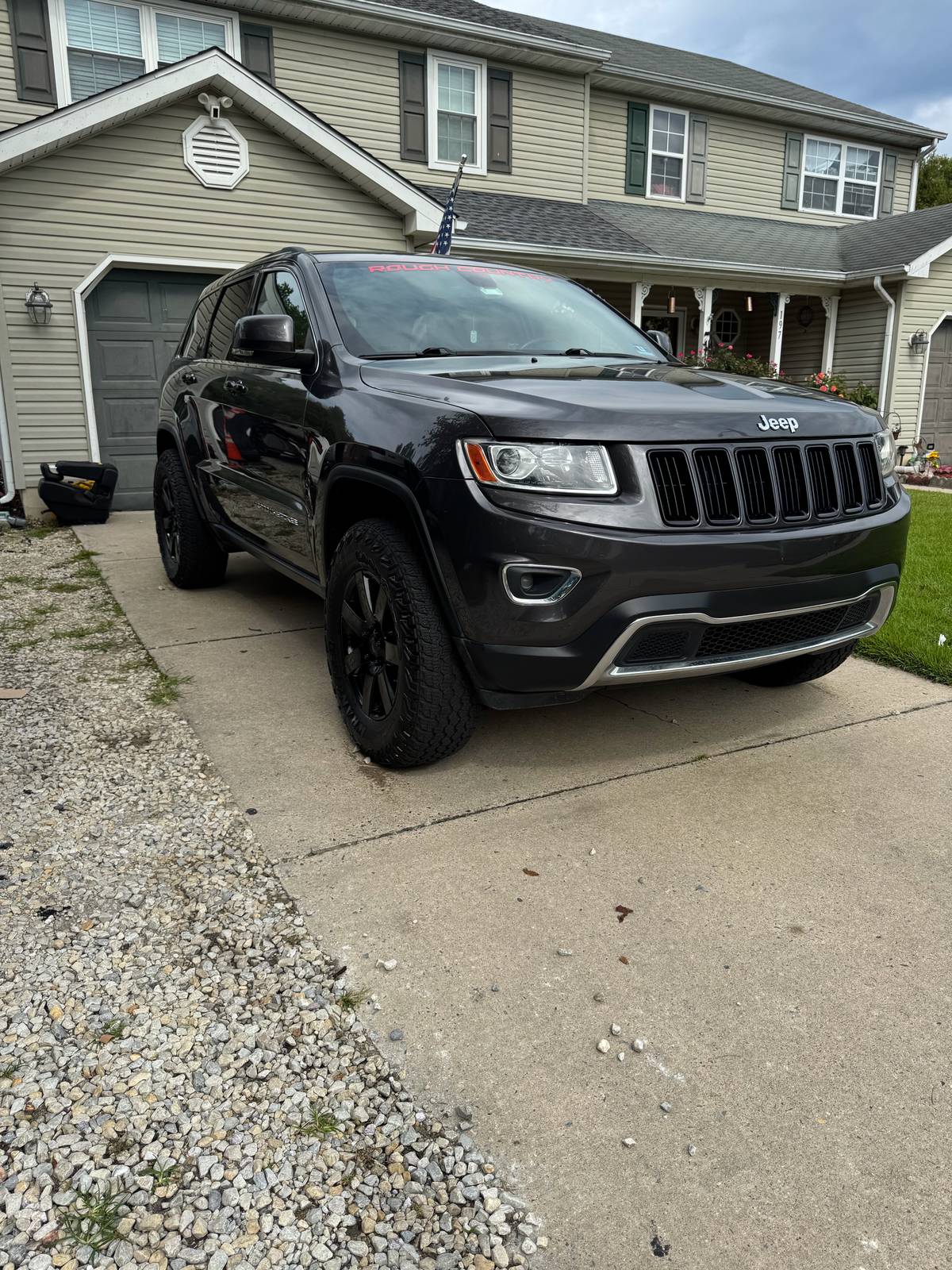Charcoal Jeep Grand Cherokee with a glossy finish after a full exterior detail, parked on a South Jersey driveway.